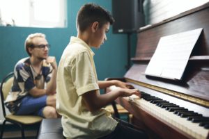 Boy having a piano lesson at music school